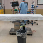 Person in surgical scrubs in operating theatre with SureWaste system.