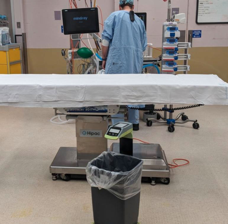 Person in surgical scrubs in operating theatre with SureWaste system.